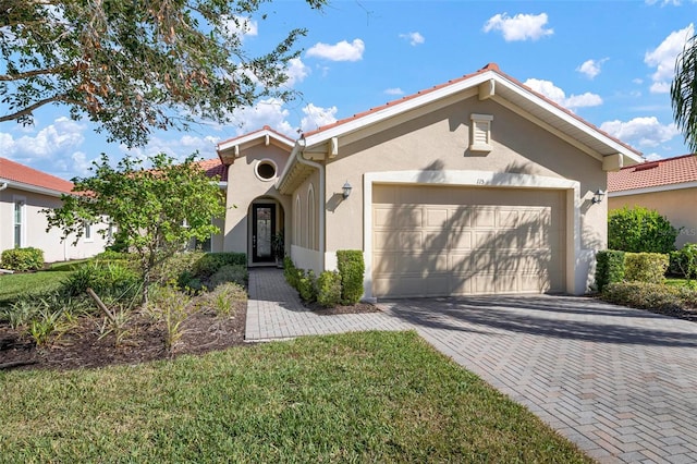 mediterranean / spanish home with a garage and a front lawn