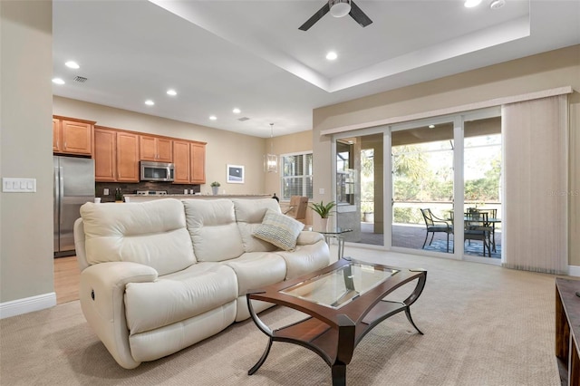 carpeted living room with ceiling fan