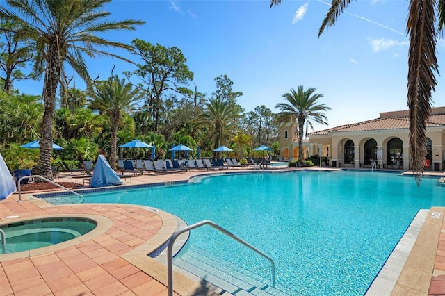 view of pool featuring a community hot tub and a patio area