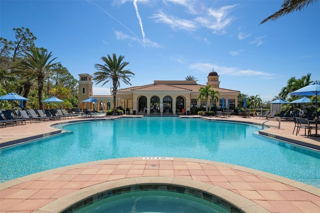 view of swimming pool with a patio area and a hot tub