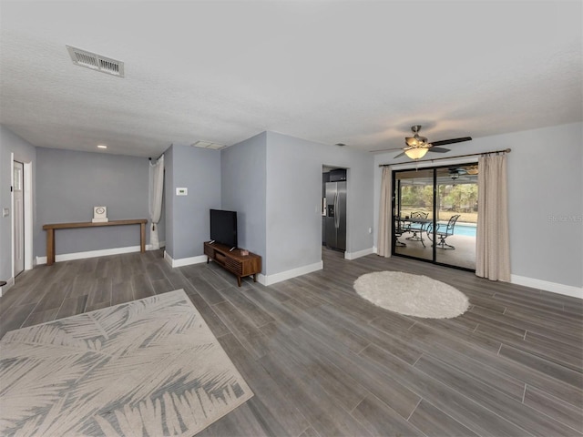 unfurnished living room featuring a textured ceiling and ceiling fan