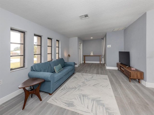 living room featuring a textured ceiling and light hardwood / wood-style floors