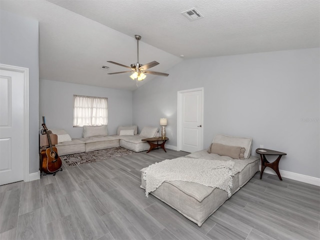 bedroom with ceiling fan, light hardwood / wood-style floors, and lofted ceiling