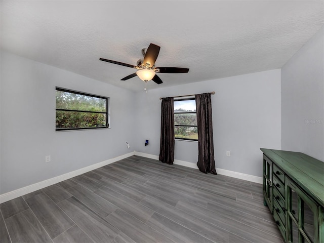 empty room featuring light wood-type flooring, a textured ceiling, and ceiling fan