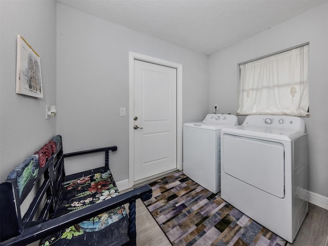 laundry area featuring a textured ceiling, separate washer and dryer, and dark hardwood / wood-style floors