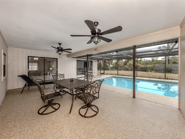 view of pool with glass enclosure, ceiling fan, and a patio