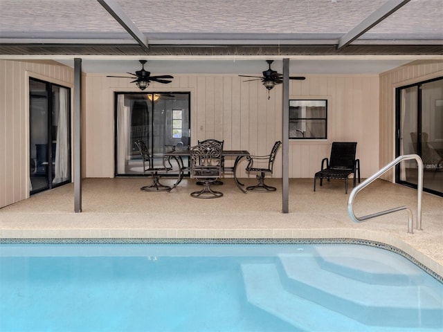 view of swimming pool featuring a patio, glass enclosure, and ceiling fan