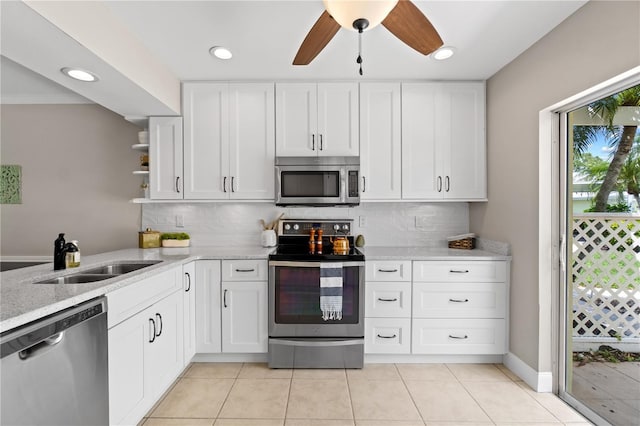 kitchen with decorative backsplash, white cabinetry, sink, and appliances with stainless steel finishes