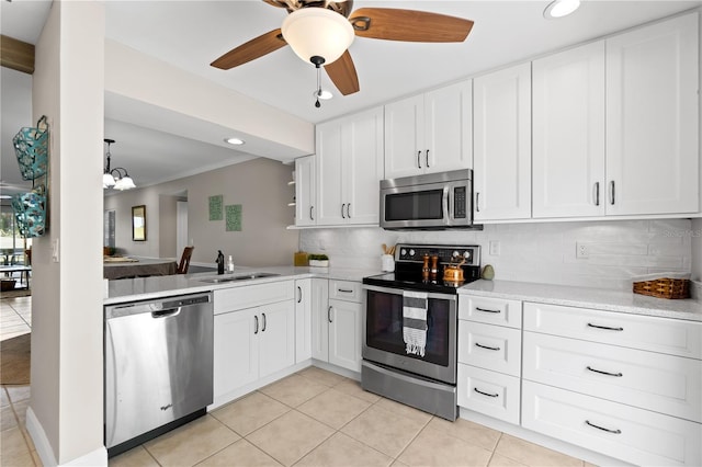 kitchen featuring stainless steel appliances, white cabinetry, tasteful backsplash, and sink