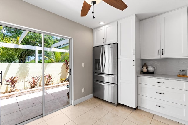 kitchen featuring backsplash, stainless steel refrigerator with ice dispenser, ceiling fan, light tile patterned floors, and white cabinetry