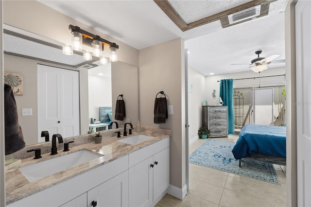 bathroom with vanity, a textured ceiling, ceiling fan, and tile patterned flooring