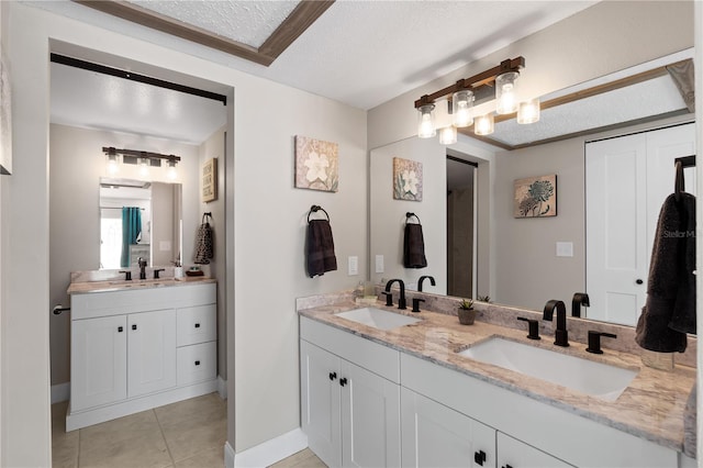 bathroom featuring tile patterned floors, vanity, a textured ceiling, and ornamental molding