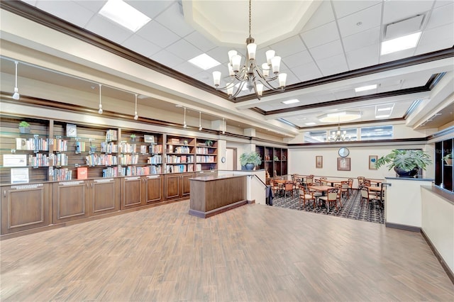 office space featuring hardwood / wood-style floors, ornamental molding, and an inviting chandelier