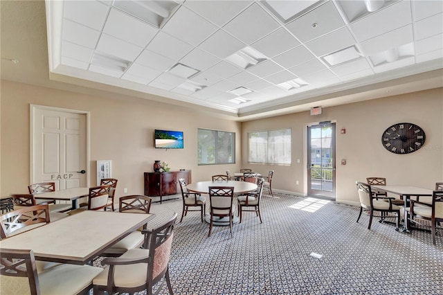 carpeted dining room featuring a tray ceiling