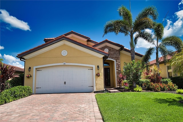 mediterranean / spanish home with a garage and a front lawn