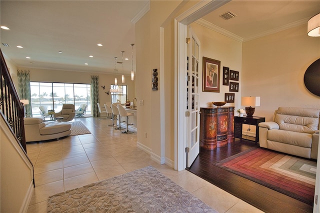 hall featuring crown molding and light tile patterned floors