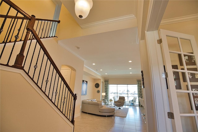 staircase featuring tile patterned floors and crown molding