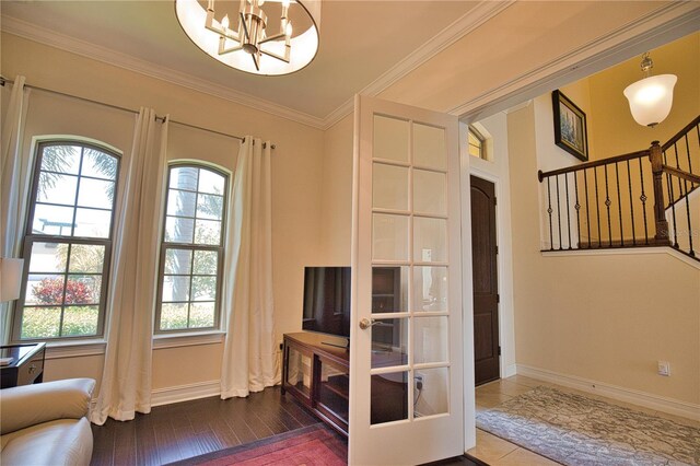 interior space featuring hardwood / wood-style floors, a notable chandelier, and ornamental molding