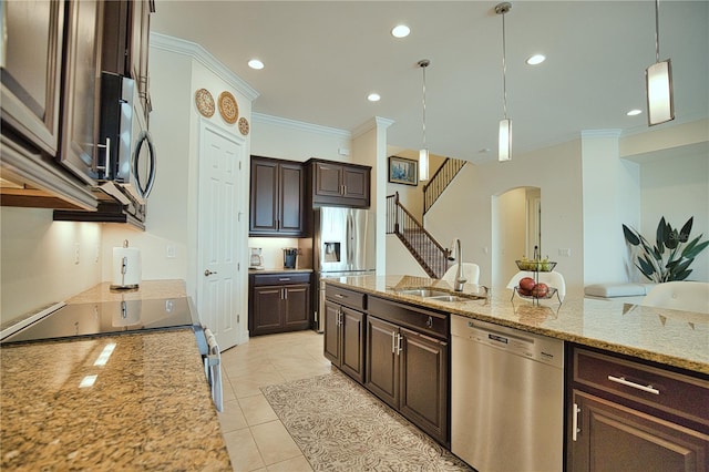 kitchen featuring sink, light tile patterned floors, appliances with stainless steel finishes, decorative light fixtures, and dark brown cabinets