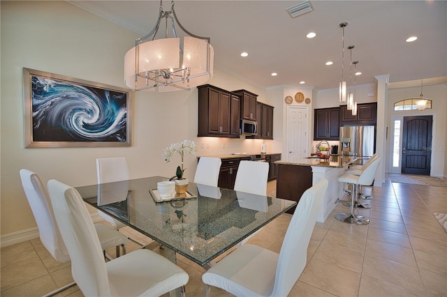 dining space with crown molding, sink, light tile patterned floors, and a notable chandelier