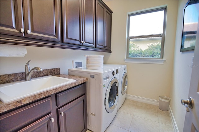 laundry room featuring light tile patterned flooring, cabinets, sink, and washing machine and clothes dryer