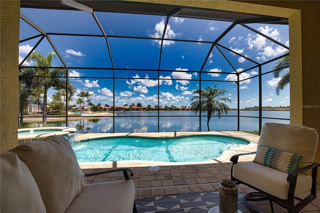 view of pool with an in ground hot tub, pool water feature, a water view, and glass enclosure