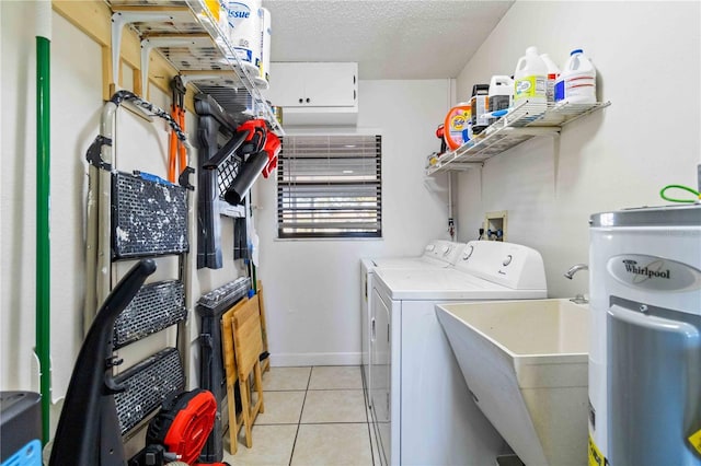 laundry area featuring light tile patterned floors, washing machine and dryer, a textured ceiling, and water heater