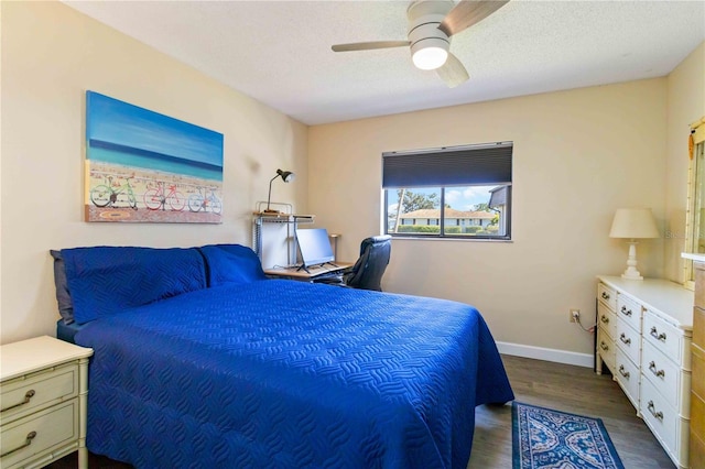 bedroom with ceiling fan, dark hardwood / wood-style flooring, and a textured ceiling