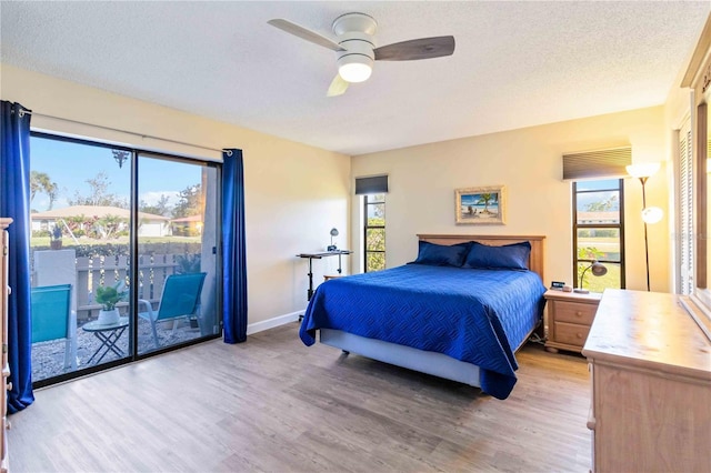 bedroom with access to outside, ceiling fan, hardwood / wood-style floors, and a textured ceiling