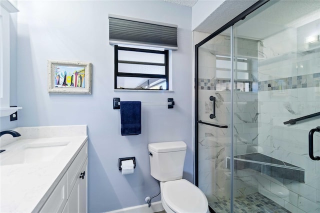 bathroom with vanity, toilet, and a shower with shower door