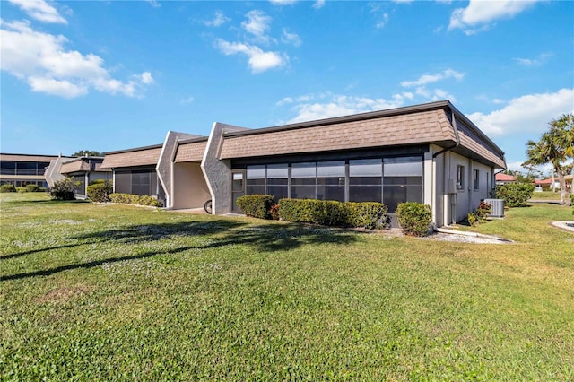 view of property exterior with a lawn and central AC unit