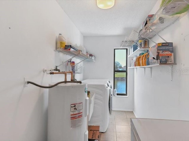 laundry room with light tile patterned floors, water heater, separate washer and dryer, and a textured ceiling