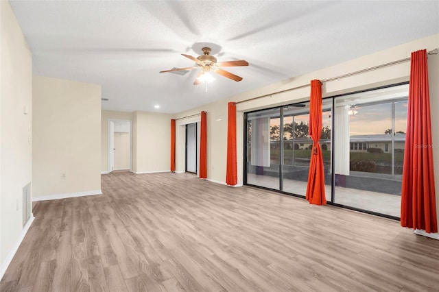 empty room featuring light wood-type flooring, ceiling fan, and a textured ceiling