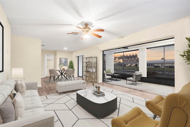 living room with ceiling fan and light hardwood / wood-style floors