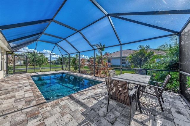 view of pool with a patio area and glass enclosure