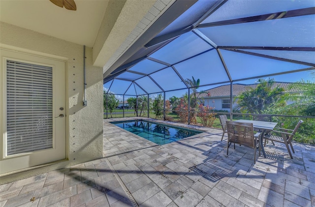 view of swimming pool featuring glass enclosure and a patio area