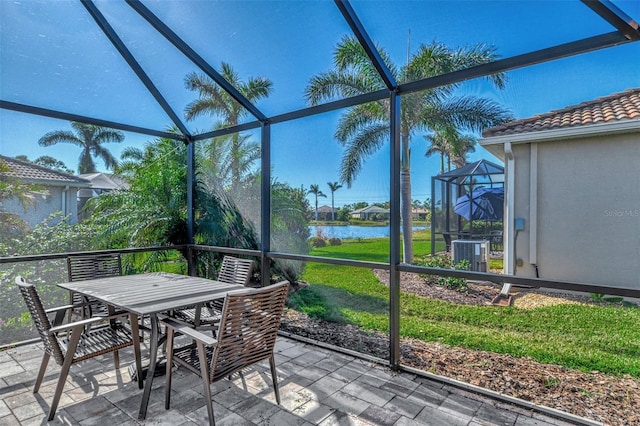 sunroom featuring a water view