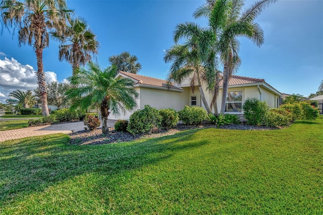 11679 Anhinga Ave, Venice, FL 34292 - view of property exterior featuring a tiled roof, a yard, decorative driveway, and stucco siding