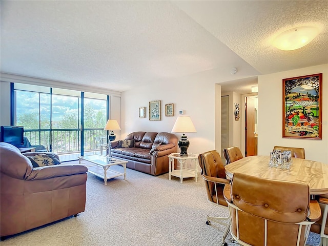 living room featuring carpet flooring, a textured ceiling, and a wall of windows