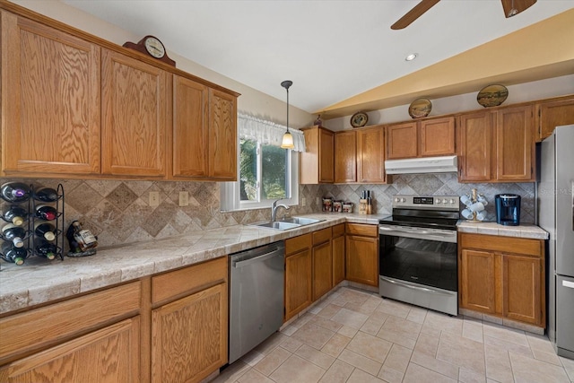 kitchen with appliances with stainless steel finishes, backsplash, vaulted ceiling, and sink