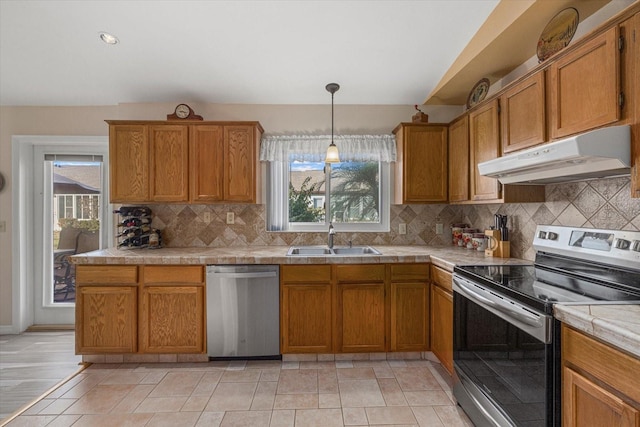 kitchen with decorative light fixtures, backsplash, stainless steel appliances, and sink