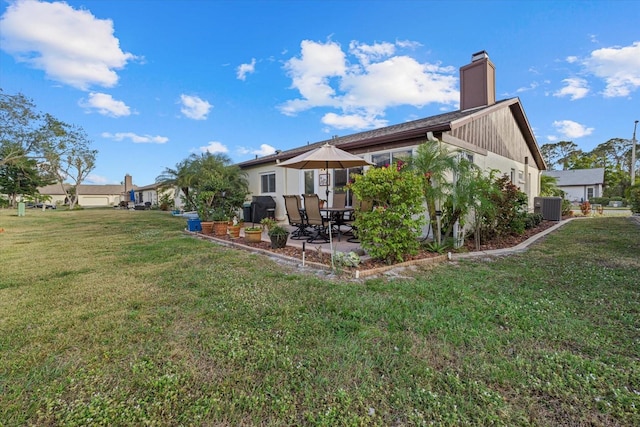 rear view of property with a lawn, central AC, and a patio