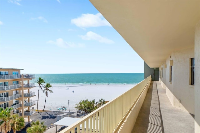 balcony featuring a water view and a view of the beach