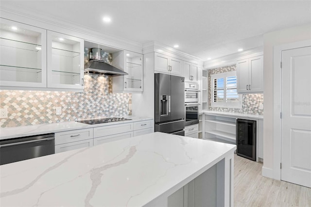 kitchen with white cabinets, beverage cooler, wall chimney range hood, and stainless steel appliances