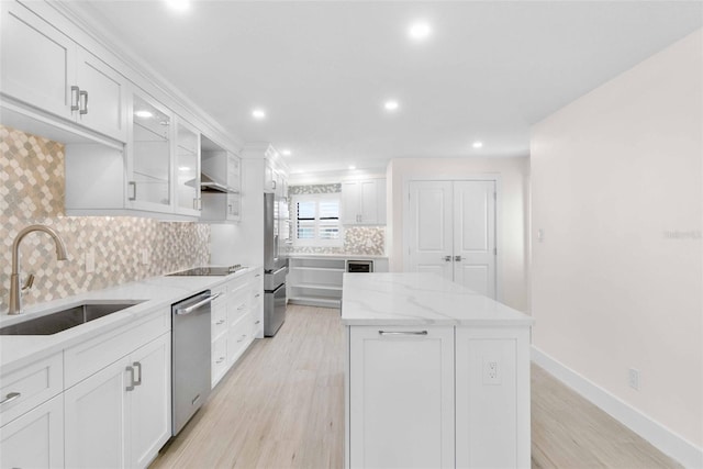 kitchen featuring appliances with stainless steel finishes, white cabinets, tasteful backsplash, and sink