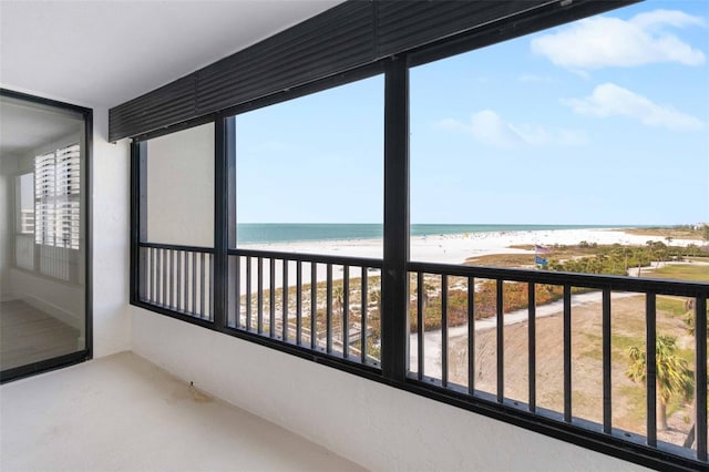 balcony featuring a water view and a beach view