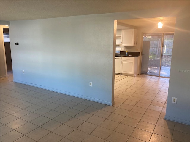 kitchen with white cabinets, dishwasher, and light tile patterned floors