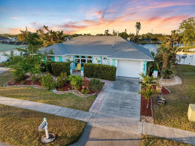 single story home featuring a lawn and a garage