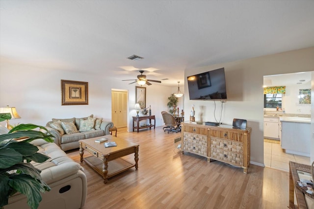 living room featuring light wood-type flooring and ceiling fan