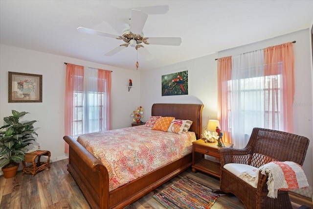 bedroom with dark hardwood / wood-style flooring and ceiling fan